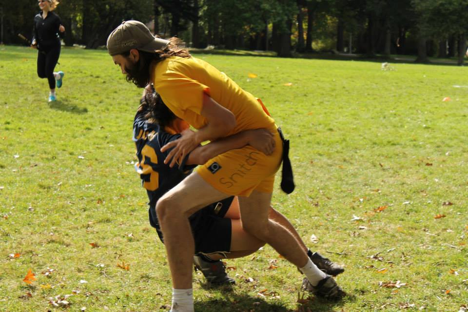 Snitch in UVic Vs. UBC game tosses UBC Seeker to the ground.