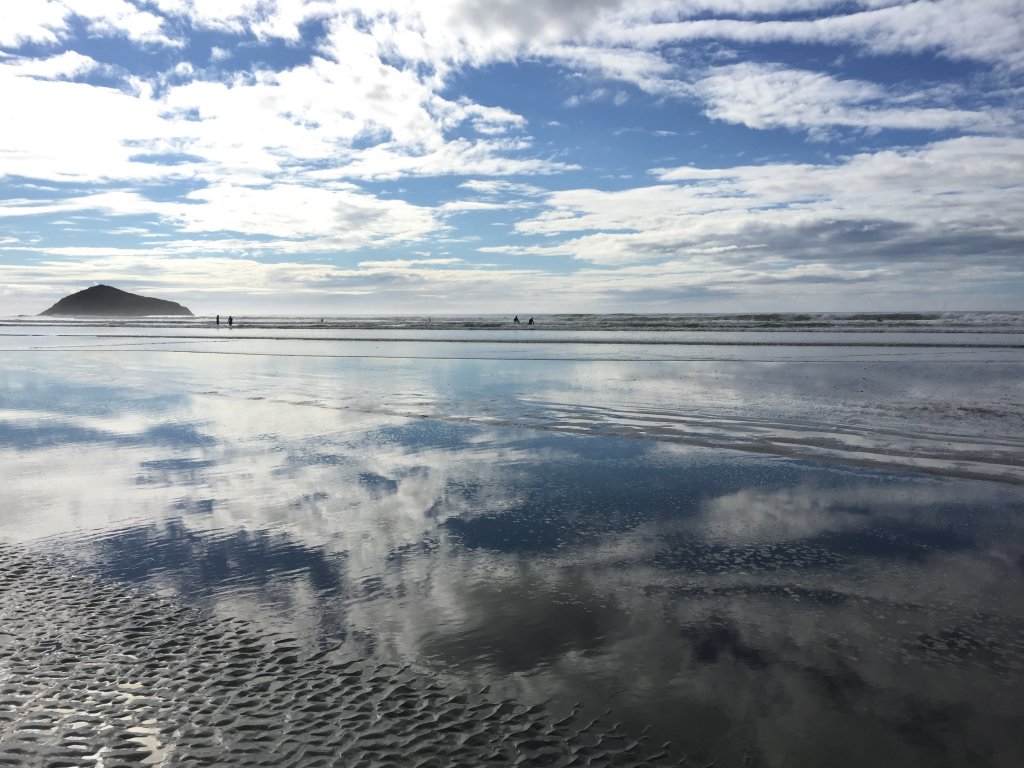 I took this photo in Tofino on a camping trip in 2016. The thin layer of water on the beach provided the perfect mirror to reflect the clouds and the sky. 